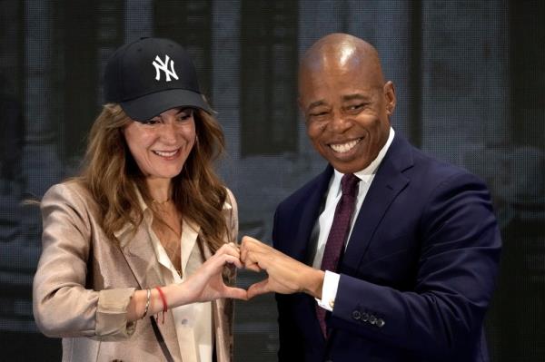 Adams makes a hand heart with AT&T Mexico CEO Monica Aspe after an October forum in Mexico City.
